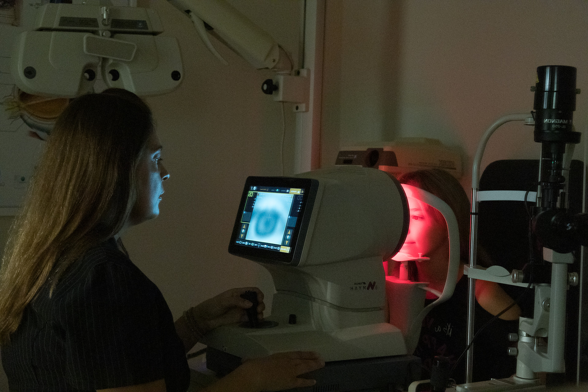 Nena fent-se una exploració visual amb l’optometrista